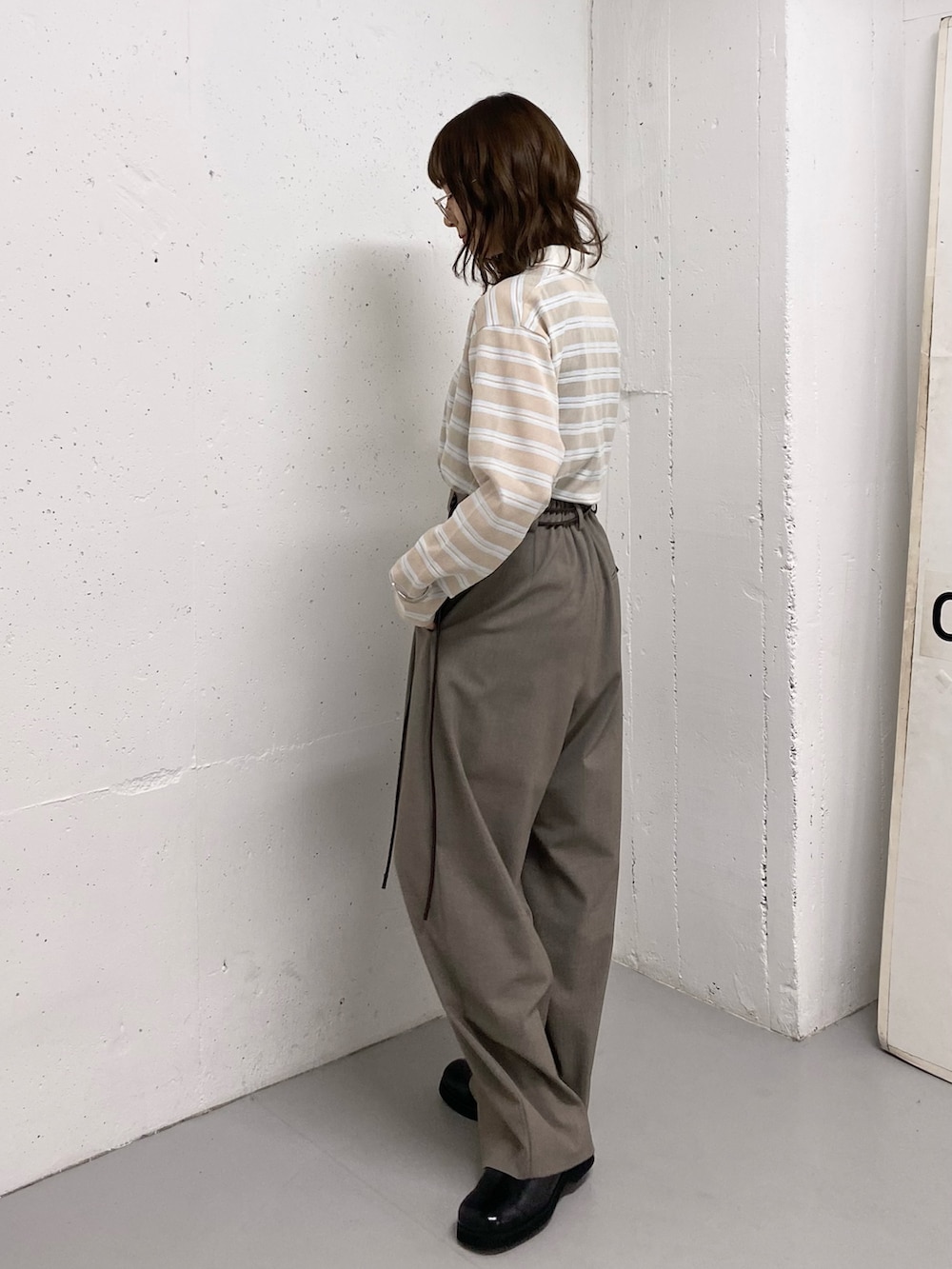 ブラック系のトートバッグ、ベージュ系のシャツ/ブラウス、ブラック系のサンダルを着用したレディースの春コーディネートの6枚目の写真
