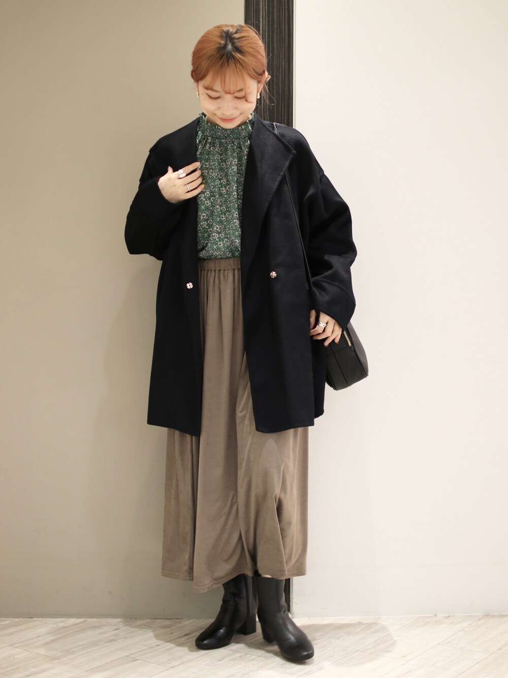 ブラウン系のスカート、ブラック系のブーツ、ブラック系のショルダーバッグを着用したレディースの冬コーディネートの2枚目の写真