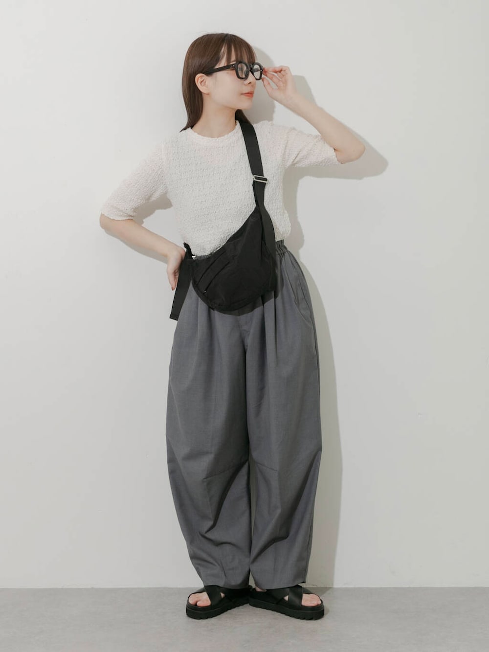 グレー系のその他パンツ、ホワイト系のTシャツ/カットソー、ブラック系のサンダルを着用したレディースの春コーディネートの4枚目の写真