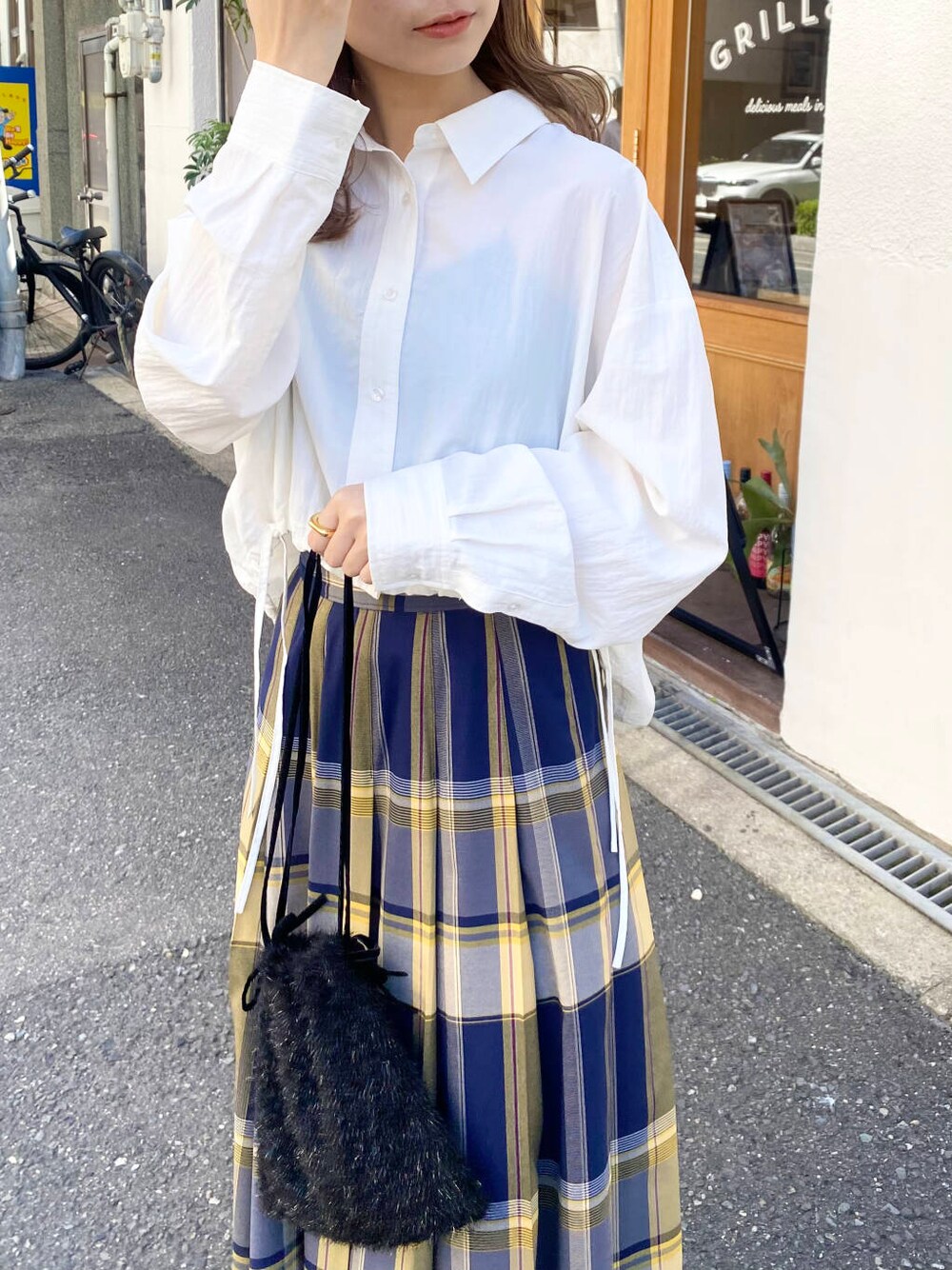 グレー系のスニーカー、ホワイト系のシャツ/ブラウス、ブルー系のスカートを着用したレディースの秋コーディネートの7枚目の写真