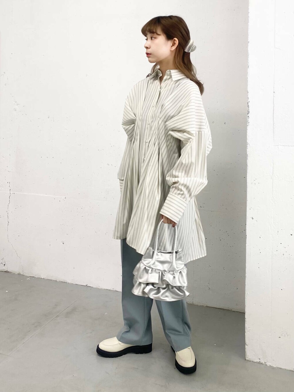 ブルー系のその他パンツ、ホワイト系のローファー、シルバー系のハンドバッグを着用したレディースの春コーディネートの4枚目の写真