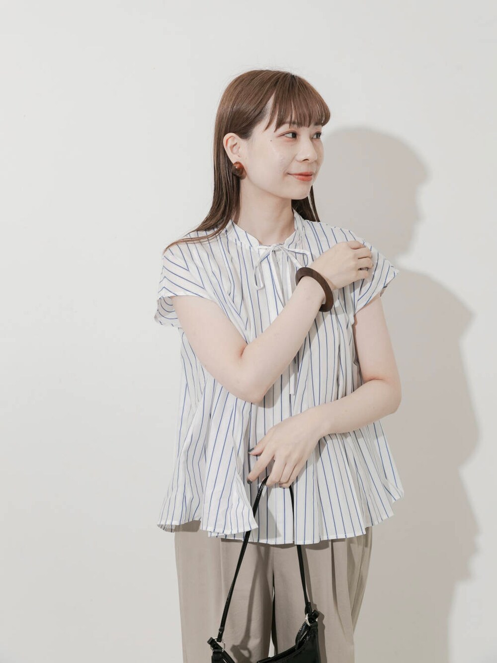 ベージュ系のその他パンツ、ブラック系のショルダーバッグ、ブラック系のバレエシューズを着用したレディースの夏コーディネートの4枚目の写真