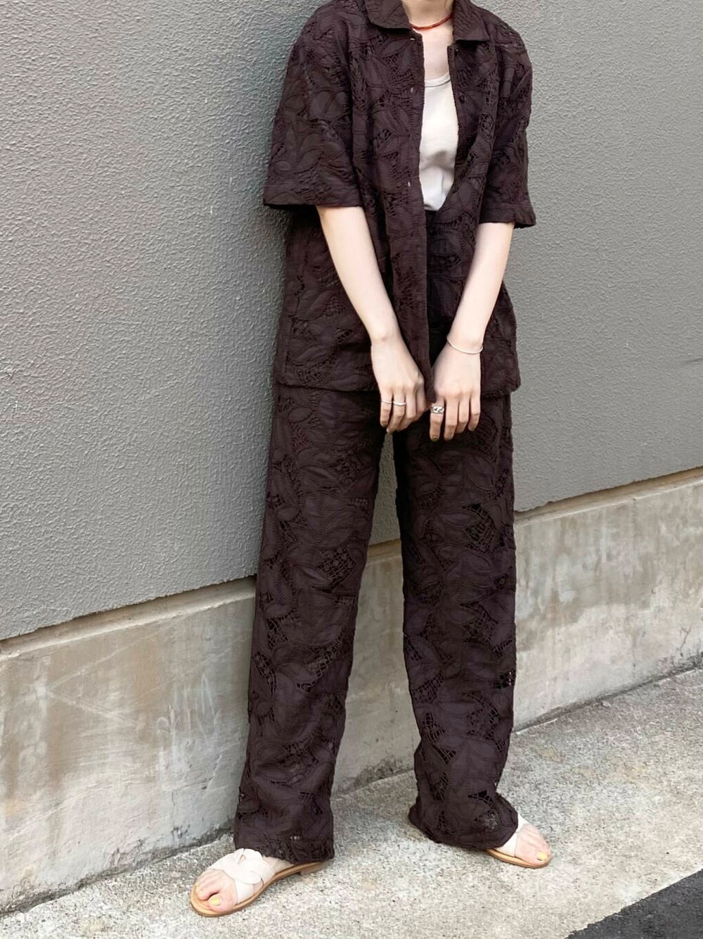 ベージュ系のタンクトップ、ホワイト系のサンダル、ブラウン系のその他パンツを着用したレディースの夏コーディネートの4枚目の写真