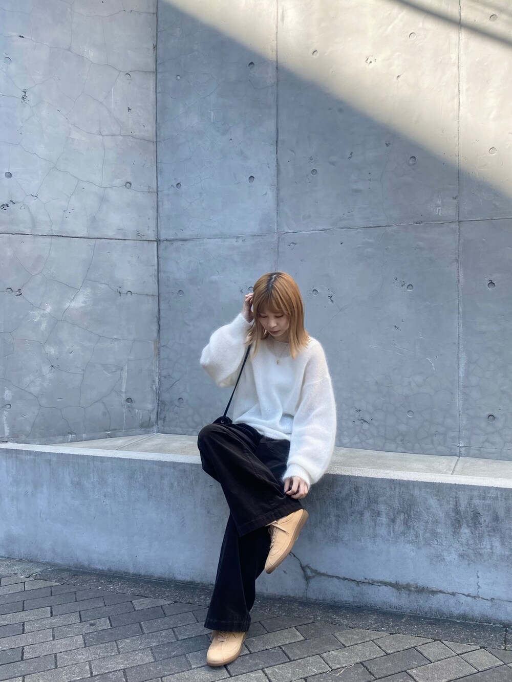 グレー系のその他パンツ、ホワイト系のニット/セーター、ベージュ系のスニーカーを着用したレディースの秋コーディネートの6枚目の写真