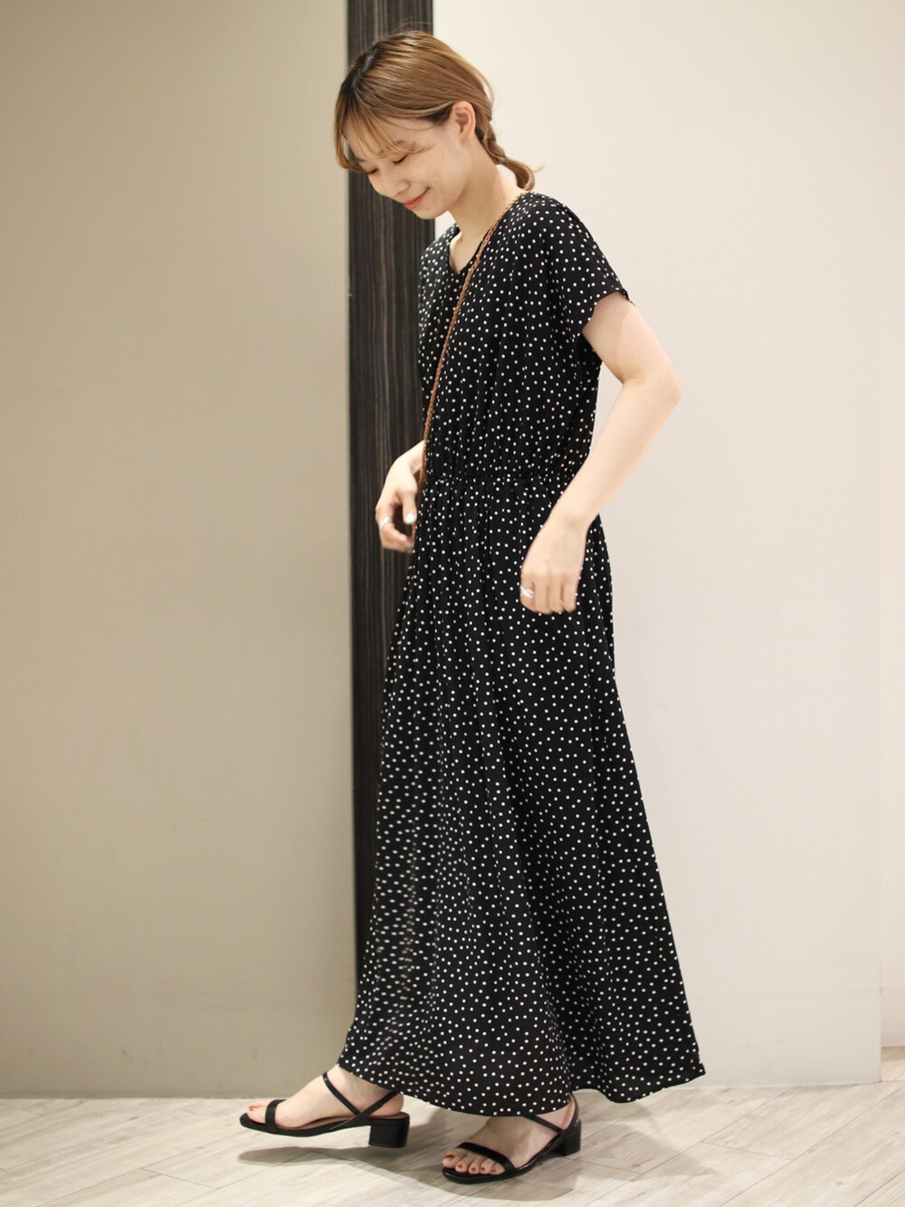 ブラック系のワンピース、ベージュ系のかごバッグ、ブラック系のサンダルを着用したレディースの夏コーディネートの3枚目の写真