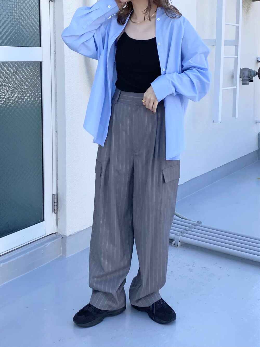 ブラック系のキャミソール、グレー系のスニーカー、ブルー系のシャツ/ブラウスを着用したレディースの秋コーディネートの4枚目の写真