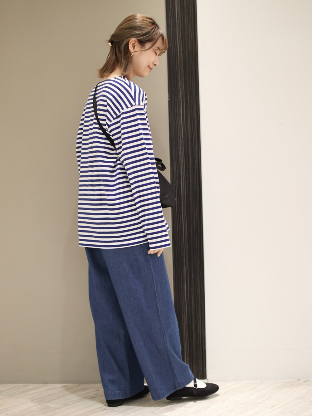 ブルー系のデニムパンツ、ブルー系のTシャツ/カットソー、ブラック系のバレエシューズを着用したレディースの冬コーディネートの3枚目の写真