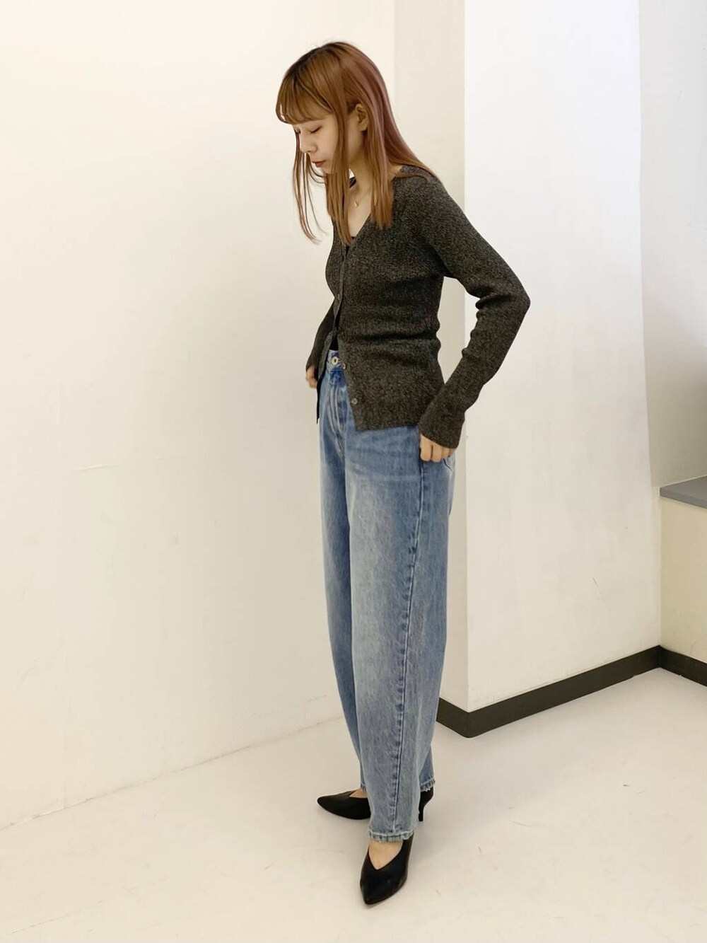 ブルー系のデニムパンツ、ブラック系のキャミソール、ブラック系のカーディガン/ボレロを着用したレディースの秋コーディネートの3枚目の写真