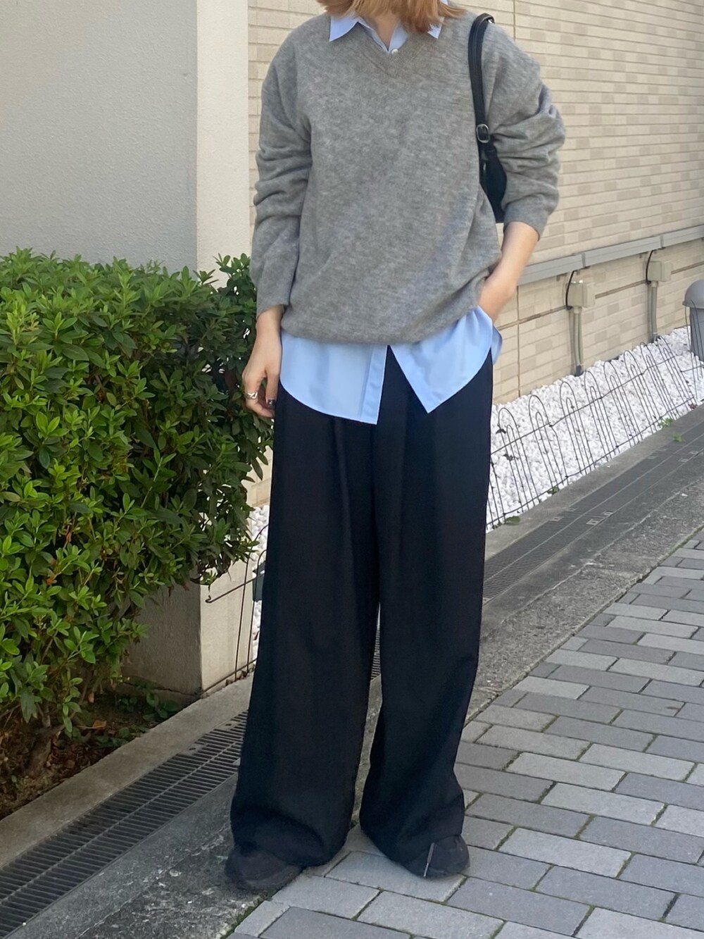 ブルー系のシャツ/ブラウス、ブラック系のボストンバッグ、グレー系のニット/セーターを着用したレディースの秋コーディネートの7枚目の写真