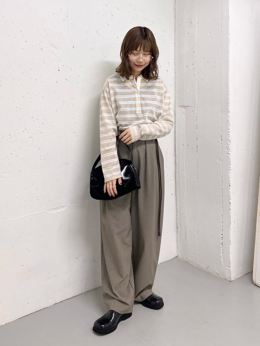 ブラック系のトートバッグ、ベージュ系のシャツ/ブラウス、ブラック系のサンダルを着用したレディースの春コーディネートの7枚目の写真
