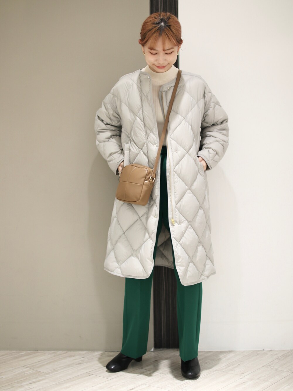 グリーン系のその他パンツ、グレー系のダウンジャケット/コート、イエロー系のショルダーバッグを着用したレディースの冬コーディネートの2枚目の写真