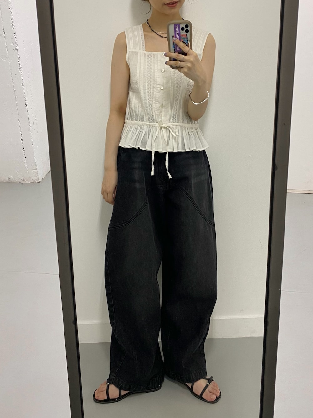ホワイト系のシャツ/ブラウス、ブラック系のデニムパンツ、ブラック系のサンダルを着用したレディースの夏コーディネートの5枚目の写真