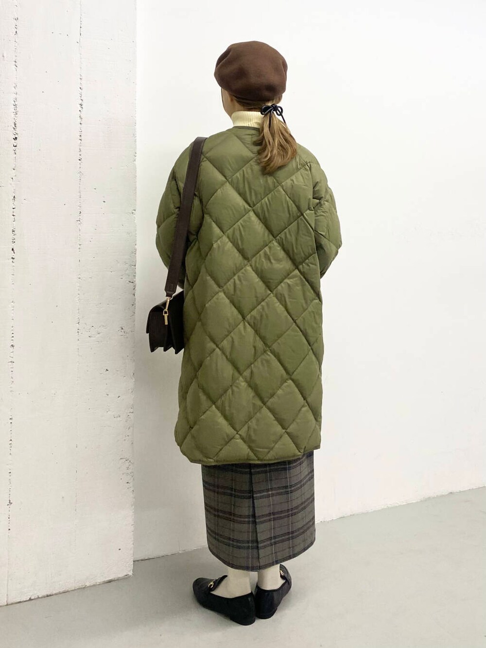 ブラック系のローファー、グリーン系のダウンジャケット/コート、ブラウン系のショルダーバッグを着用したレディースの冬コーディネートの4枚目の写真