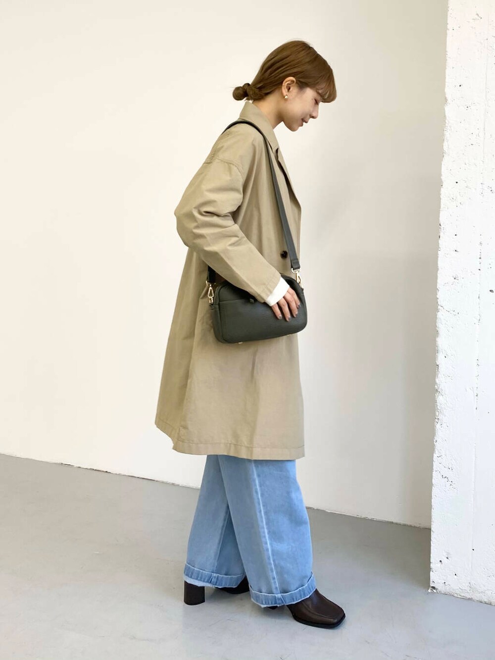 グリーン系のショルダーバッグ、ブラック系のブーツ、その他のニット/セーターを着用したレディースの冬コーディネートの5枚目の写真