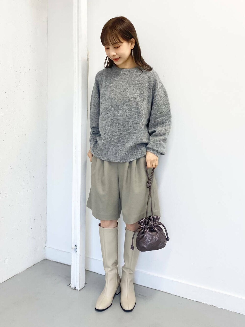 グレー系のニット/セーター、ベージュ系のその他パンツ、ホワイト系のブーツを着用したレディースの冬コーディネートの6枚目の写真