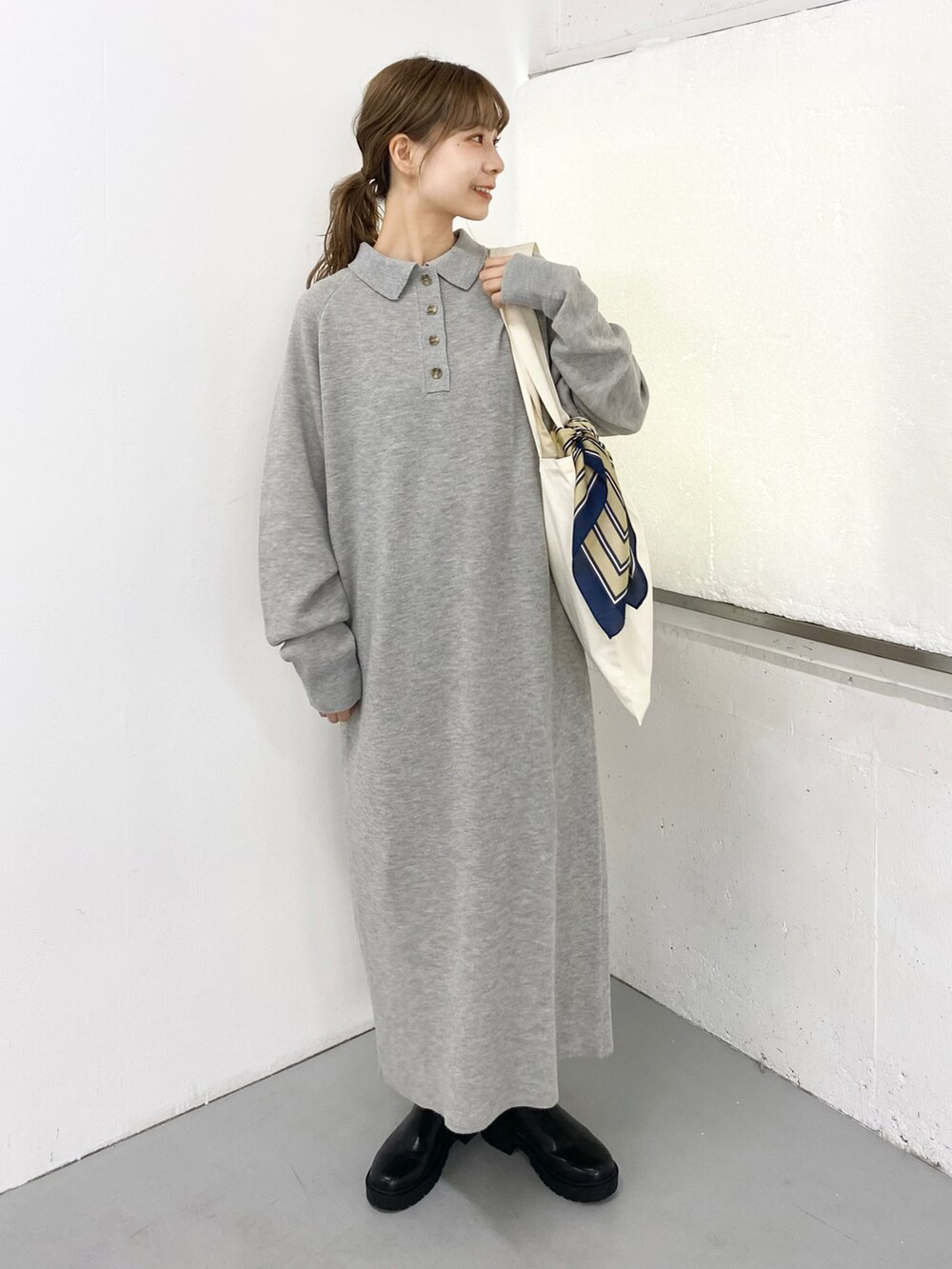 ブラック系のブーツ、グレー系のワンピース、ホワイト系のトートバッグを着用したレディースの秋コーディネートの3枚目の写真