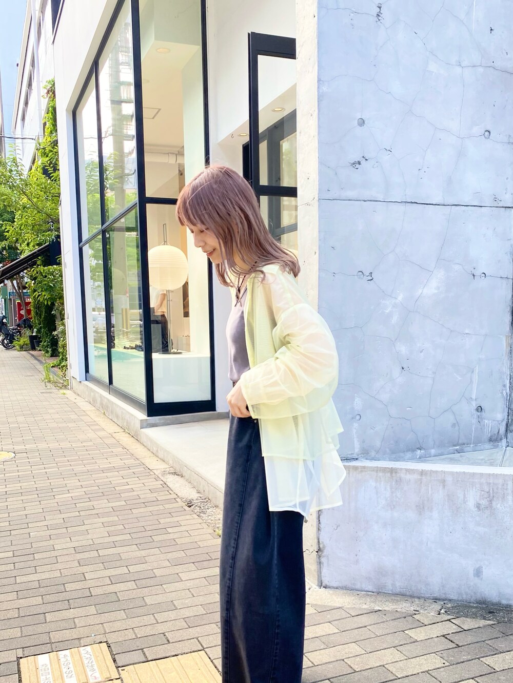 グレー系のタンクトップ、グリーン系のシャツ/ブラウス、ブラック系のデニムパンツを着用したレディースの夏コーディネートの3枚目の写真