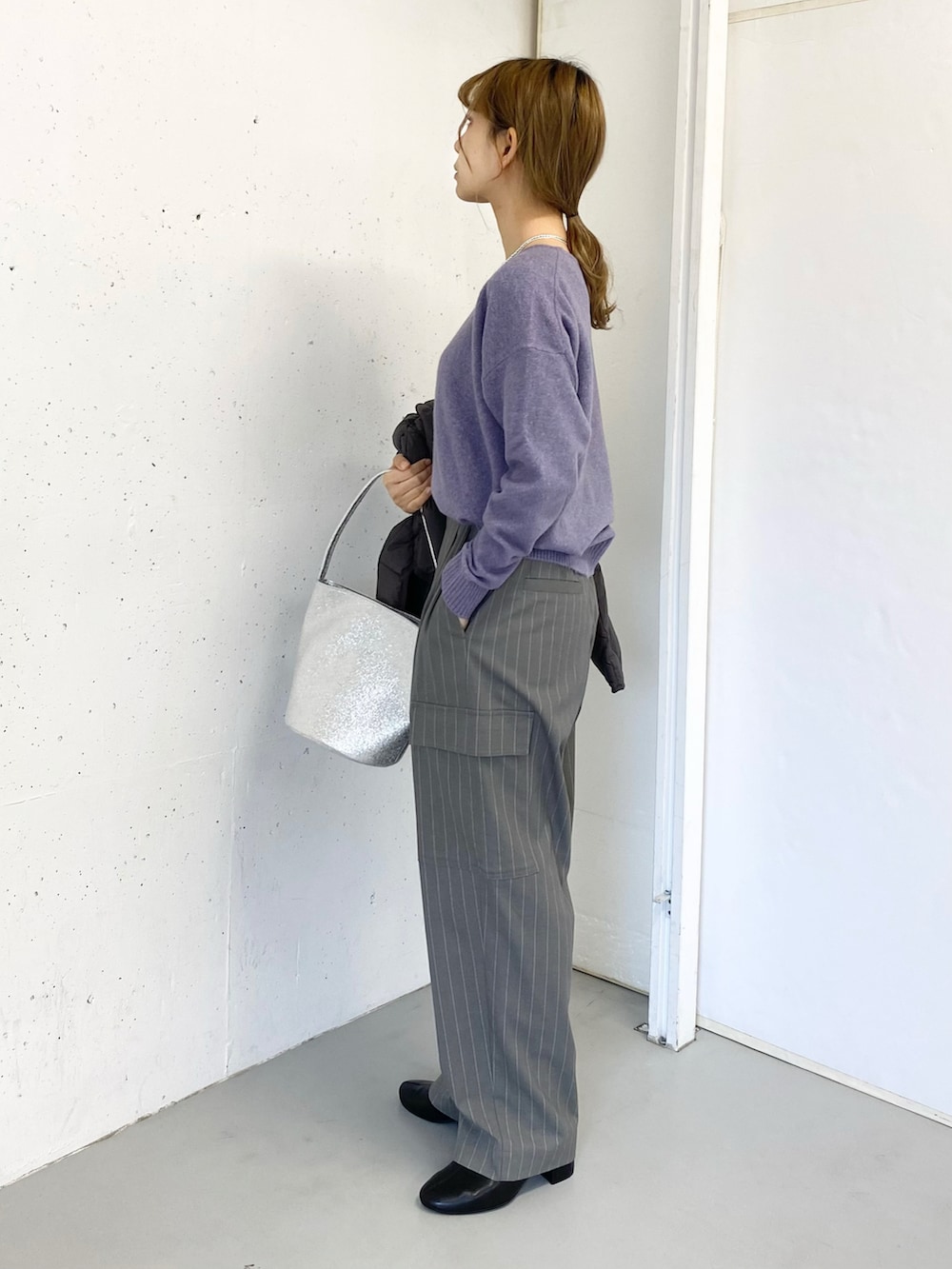 グレー系のその他パンツ、ブラック系のブーツ、シルバー系のハンドバッグを着用したレディースの冬コーディネートの4枚目の写真