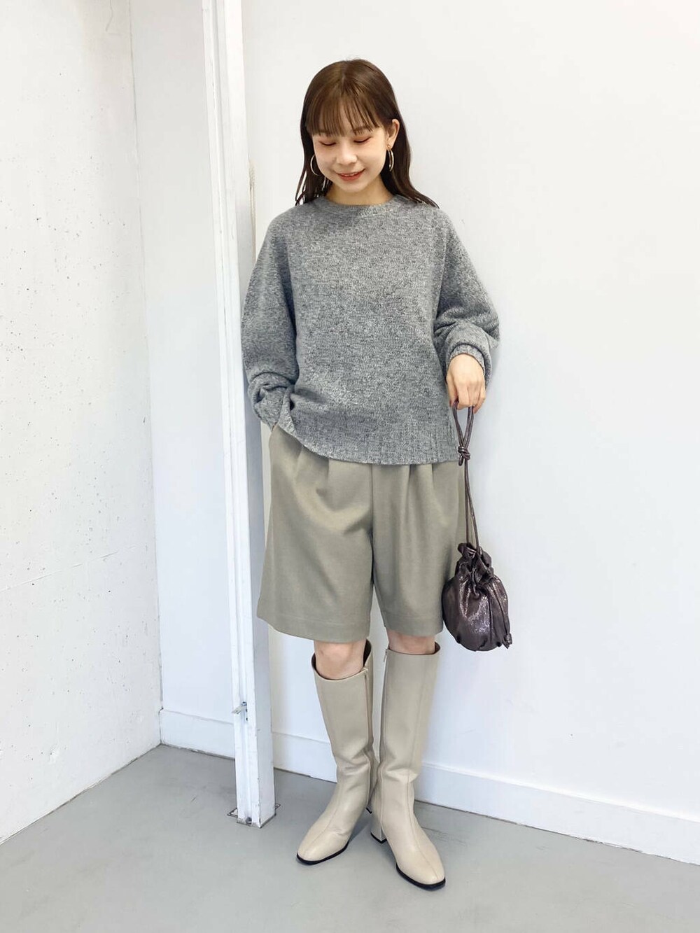 グレー系のニット/セーター、ベージュ系のその他パンツ、ホワイト系のブーツを着用したレディースの冬コーディネートの5枚目の写真