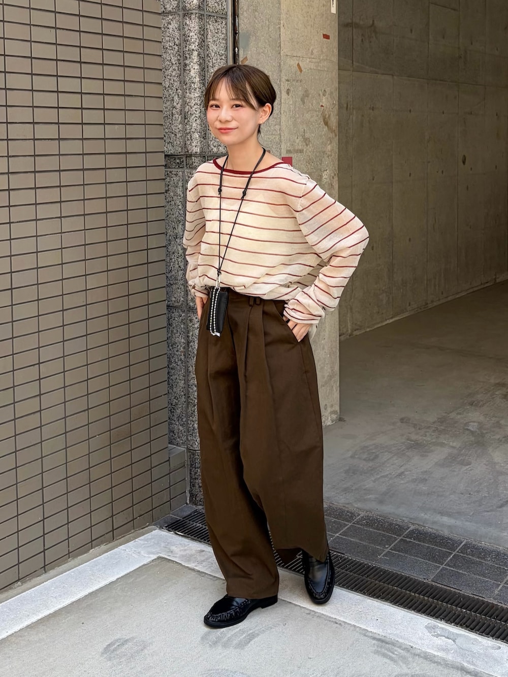 ブラウン系のその他パンツ、ベージュ系のニット/セーター、ブラック系のローファーを着用したレディースの秋コーディネートの2枚目の写真