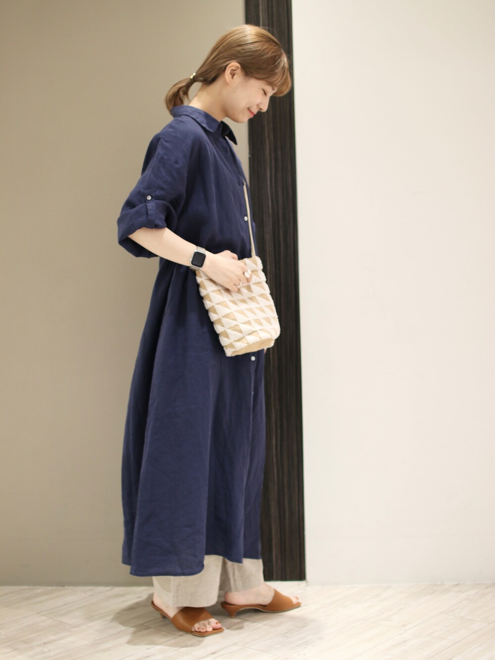 ホワイト系のショルダーバッグ、ブルー系のワンピース、イエロー系のサンダルを着用したレディースの春コーディネートの3枚目の写真