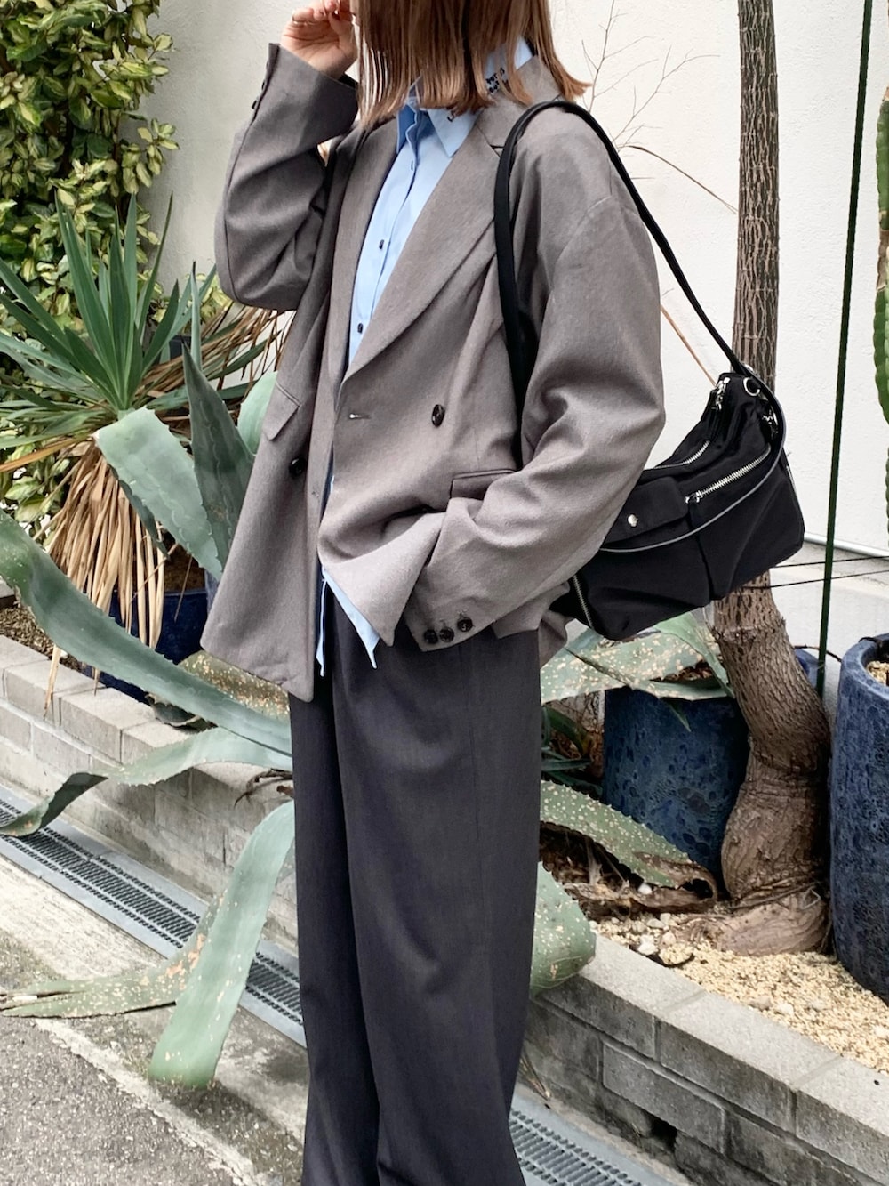 ブラック系のショルダーバッグ、グレー系のその他アウター、ブルー系のシャツ/ブラウスを着用したレディースの秋コーディネートの7枚目の写真