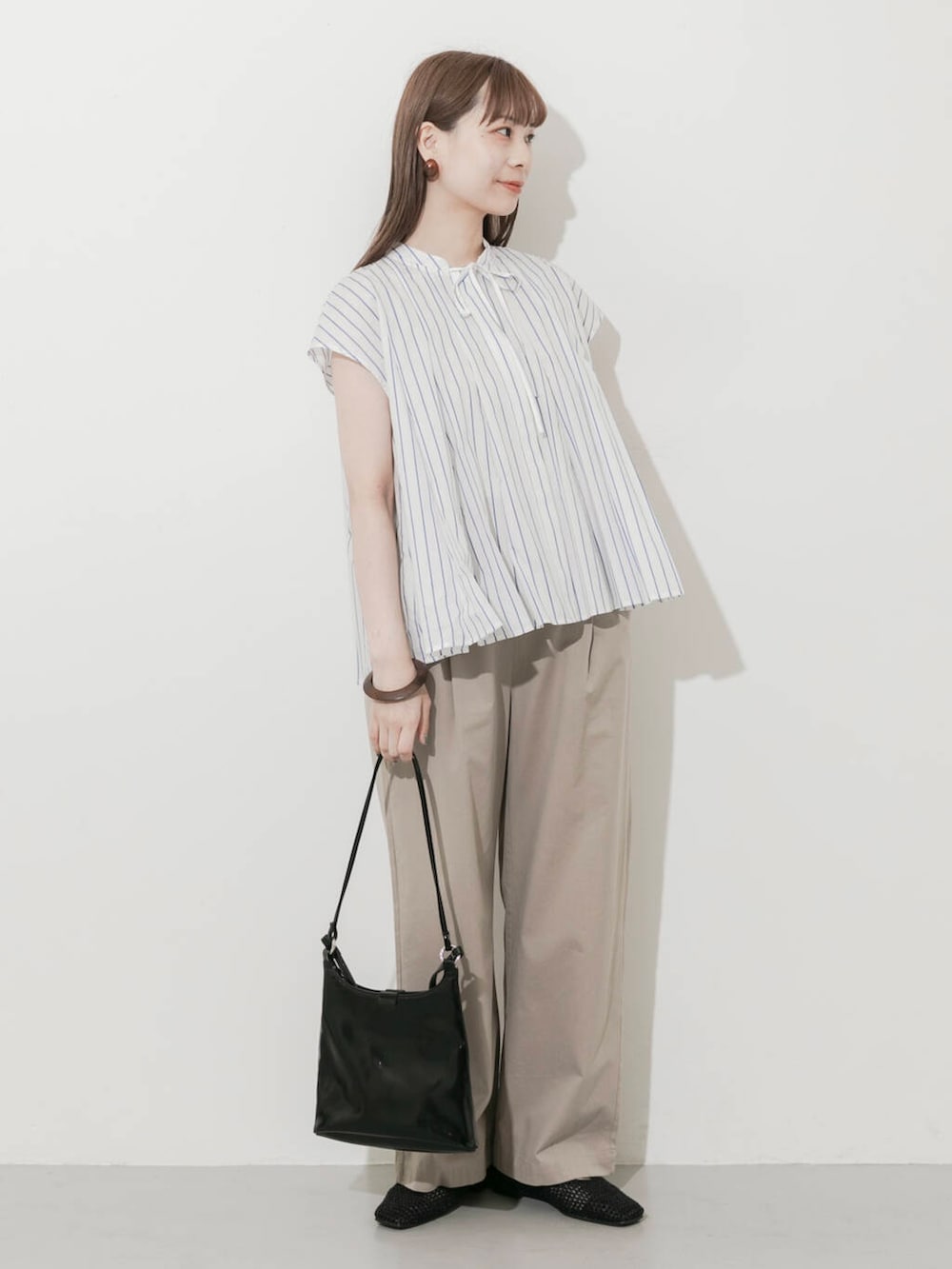 ベージュ系のその他パンツ、ブラック系のショルダーバッグ、ブラック系のバレエシューズを着用したレディースの夏コーディネートの2枚目の写真