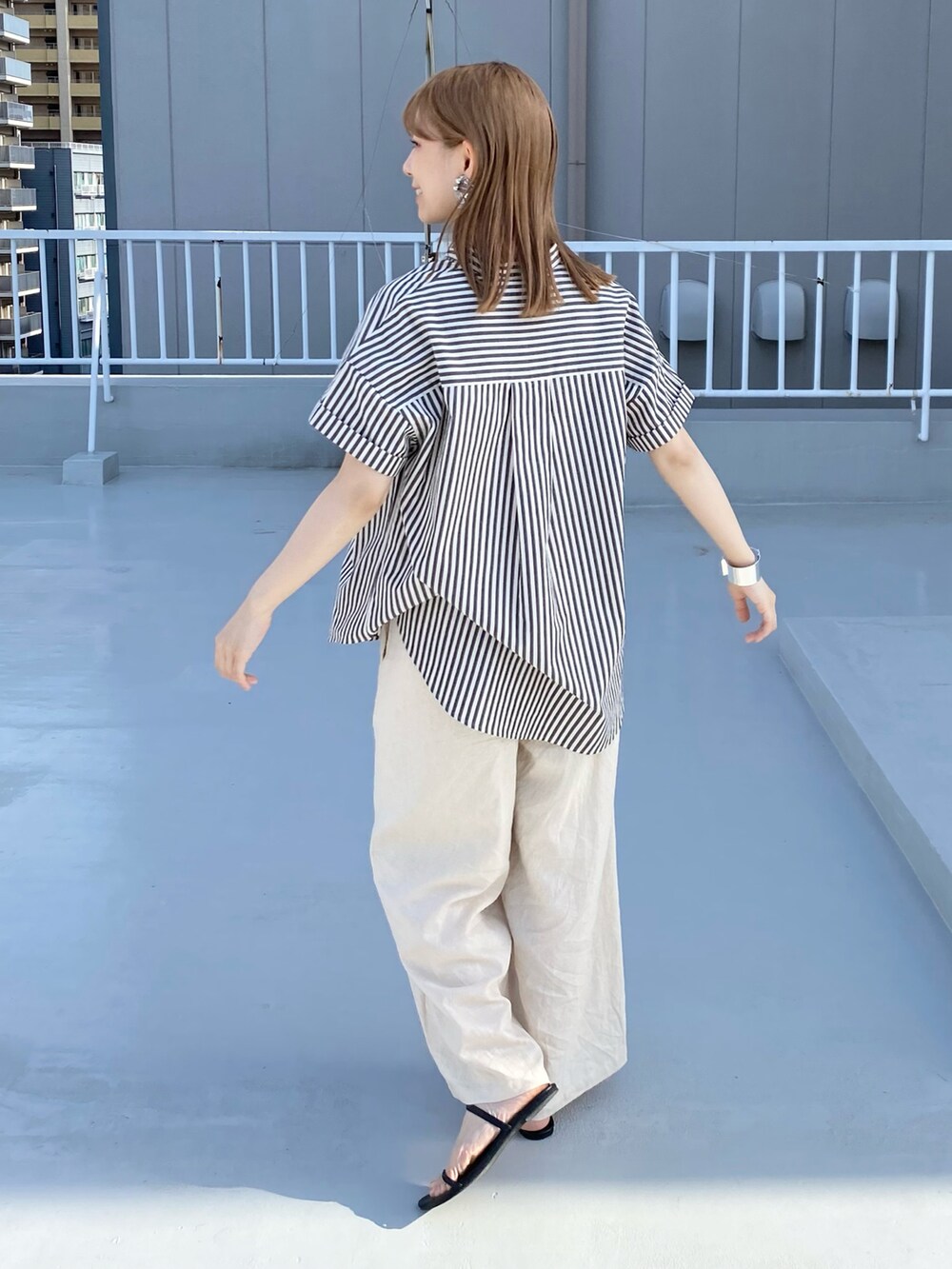 ブラック系のシャツ/ブラウス、ベージュ系のその他パンツ、ブラック系のサンダルを着用したレディースの春コーディネートの3枚目の写真