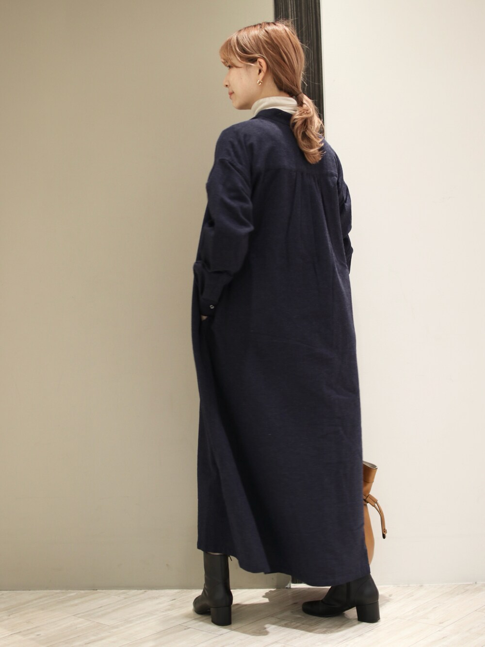 ブルー系のワンピース、ベージュ系のTシャツ/カットソー、ブラック系のブーツを着用したレディースの冬コーディネートの2枚目の写真