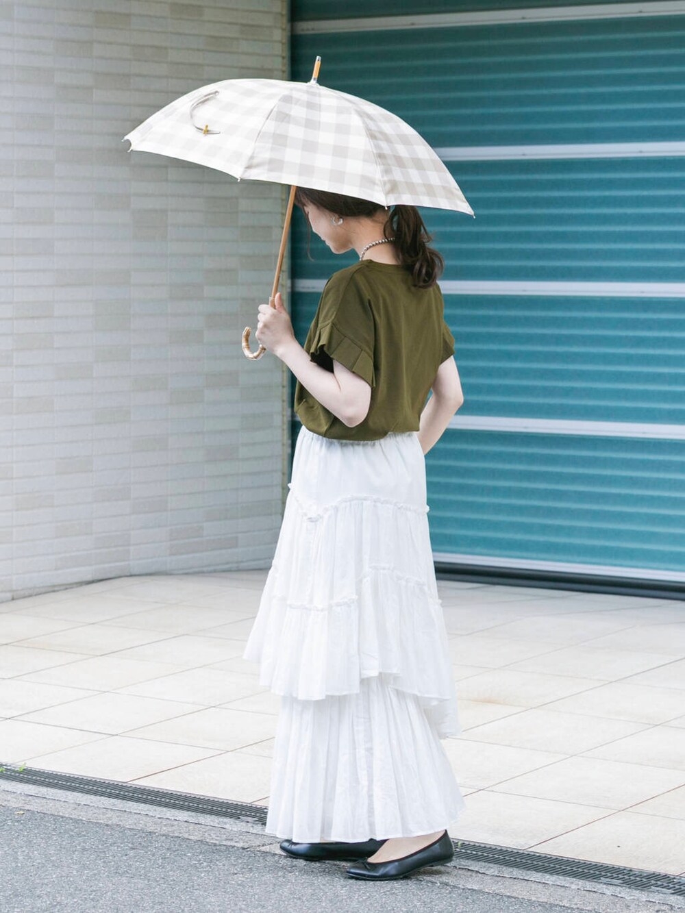 グリーン系のTシャツ/カットソー、ホワイト系のスカート、シルバー系のネックレスを着用したレディースの春コーディネートの3枚目の写真