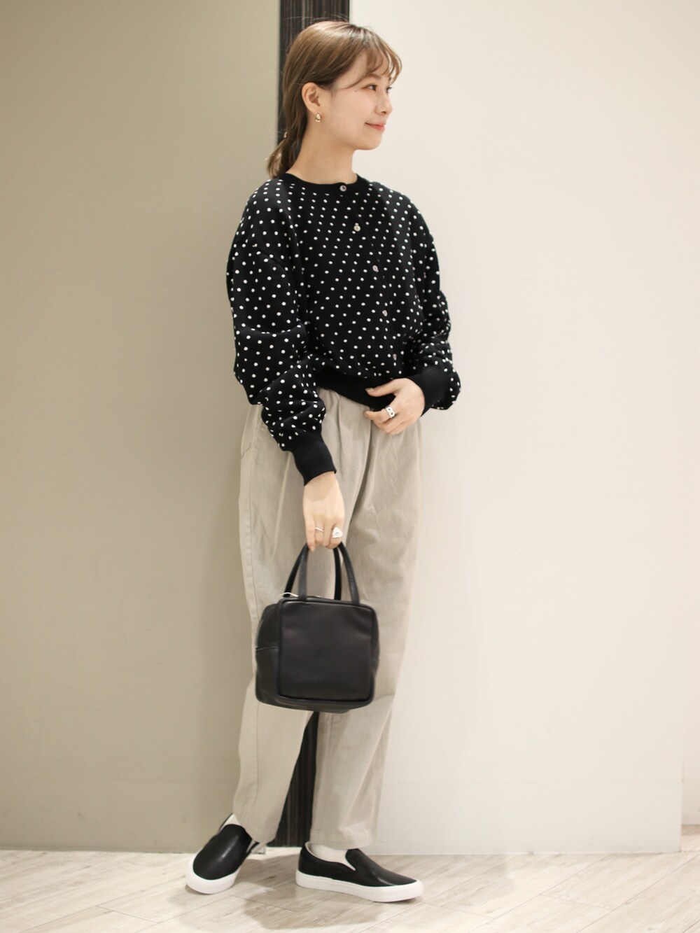 ベージュ系のその他パンツ、ブラック系のカーディガン/ボレロ、ブラック系のトートバッグを着用したレディースの冬コーディネートの2枚目の写真