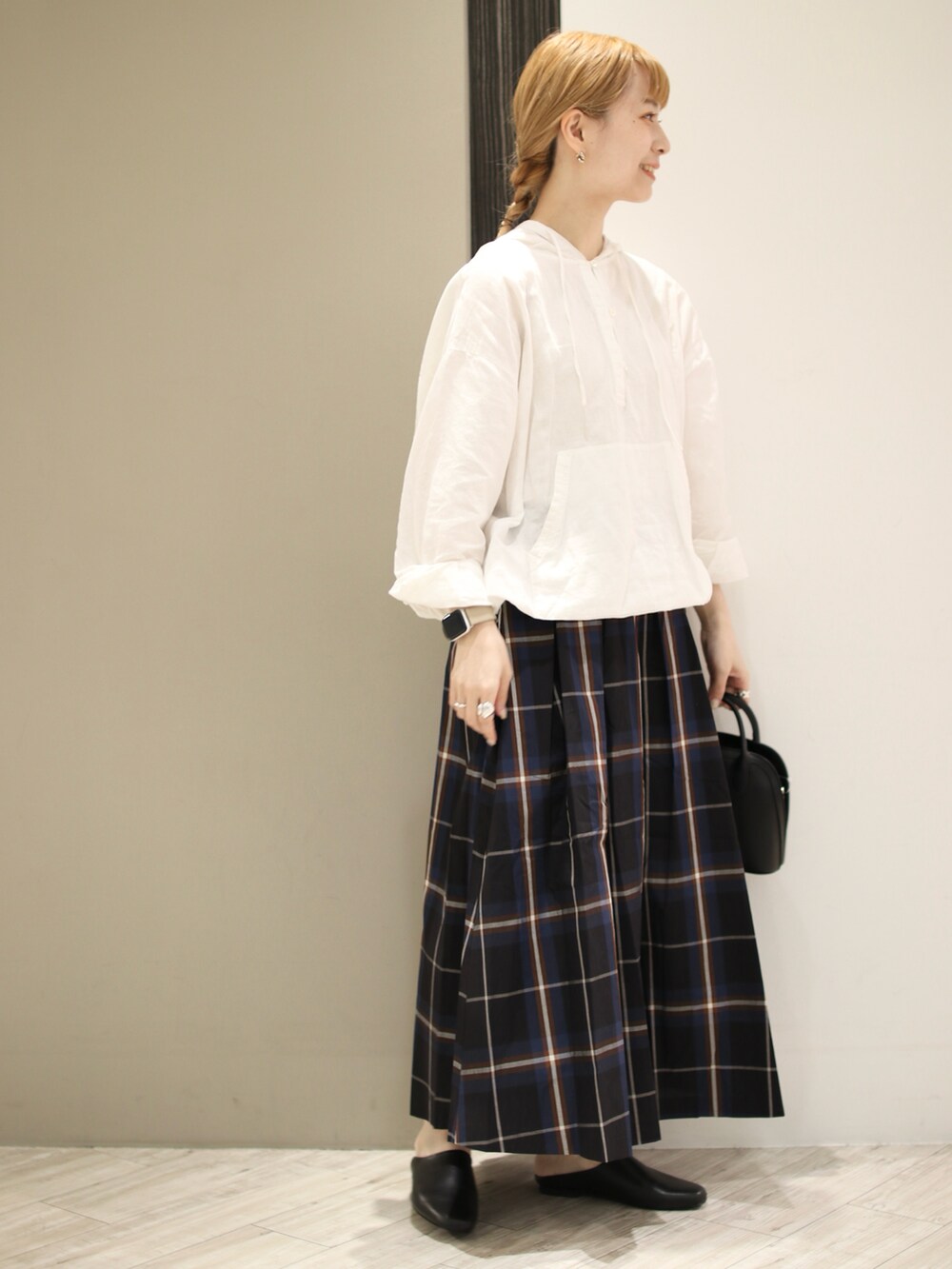 グリーン系のスカート、ブラック系のサンダル、ブラック系のショルダーバッグを着用したレディースの秋コーディネートの2枚目の写真