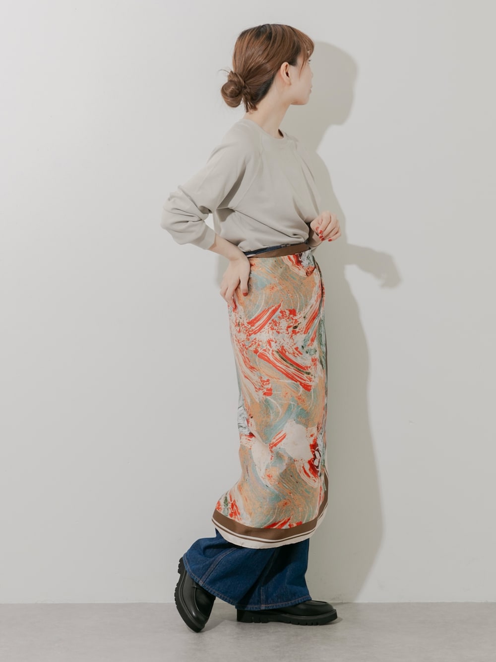 ブラック系のローファー、ベージュ系のTシャツ/カットソー、ブルー系のデニムパンツを着用したレディースの秋コーディネートの2枚目の写真