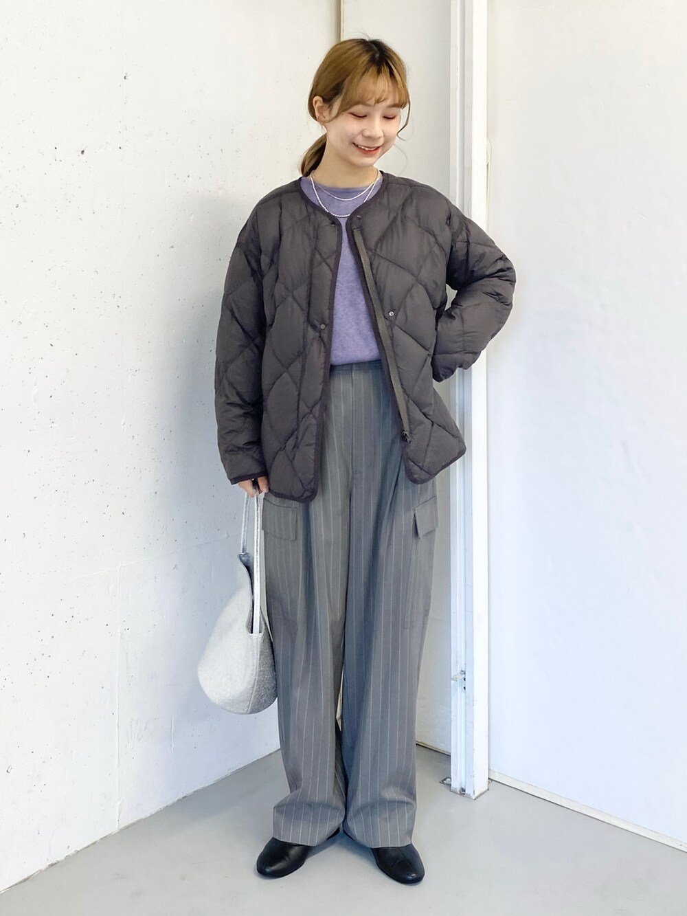 グレー系のその他パンツ、ブラック系のブーツ、シルバー系のハンドバッグを着用したレディースの冬コーディネートの2枚目の写真