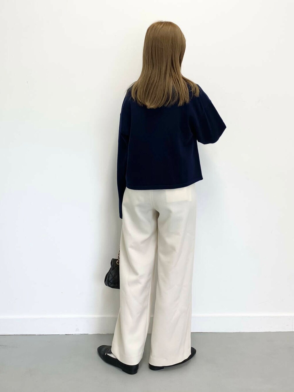 ブラック系のローファー、ブラック系のショルダーバッグ、ホワイト系のTシャツ/カットソーを着用したレディースの冬コーディネートの4枚目の写真