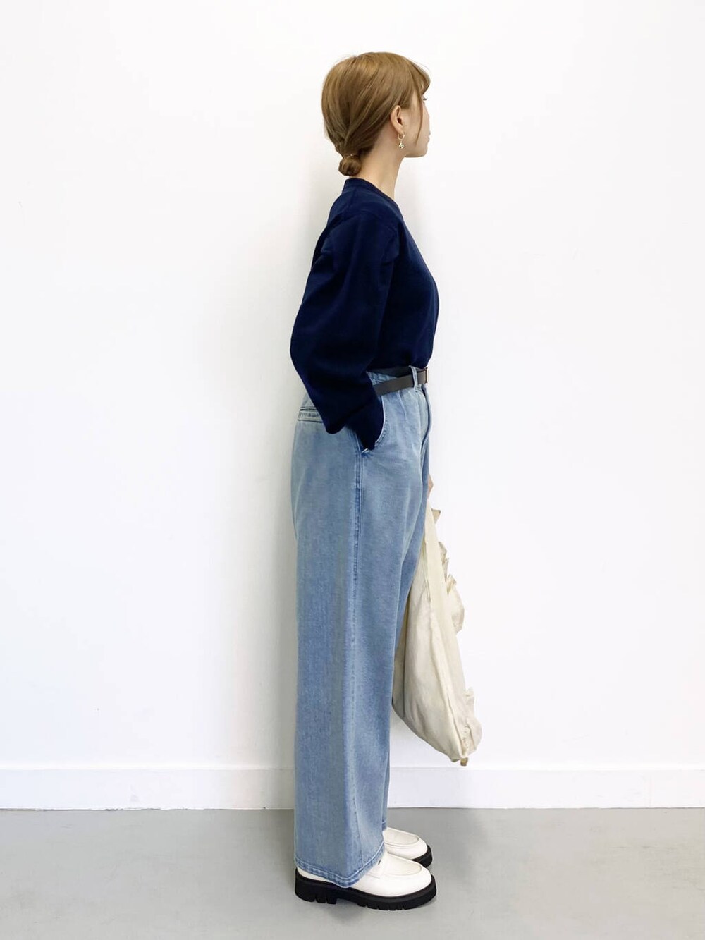 ホワイト系のローファー、ブルー系のデニムパンツ、ホワイト系のトートバッグを着用したレディースの冬コーディネートの4枚目の写真