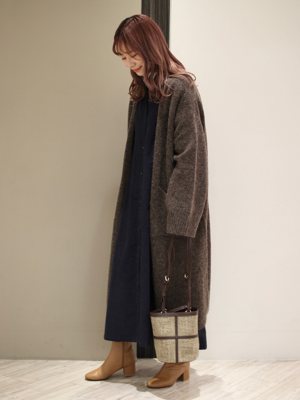 ブラウン系のショルダーバッグ、ブルー系のワンピース、ブラウン系のカーディガン/ボレロを着用したレディースの冬コーディネートの2枚目の写真