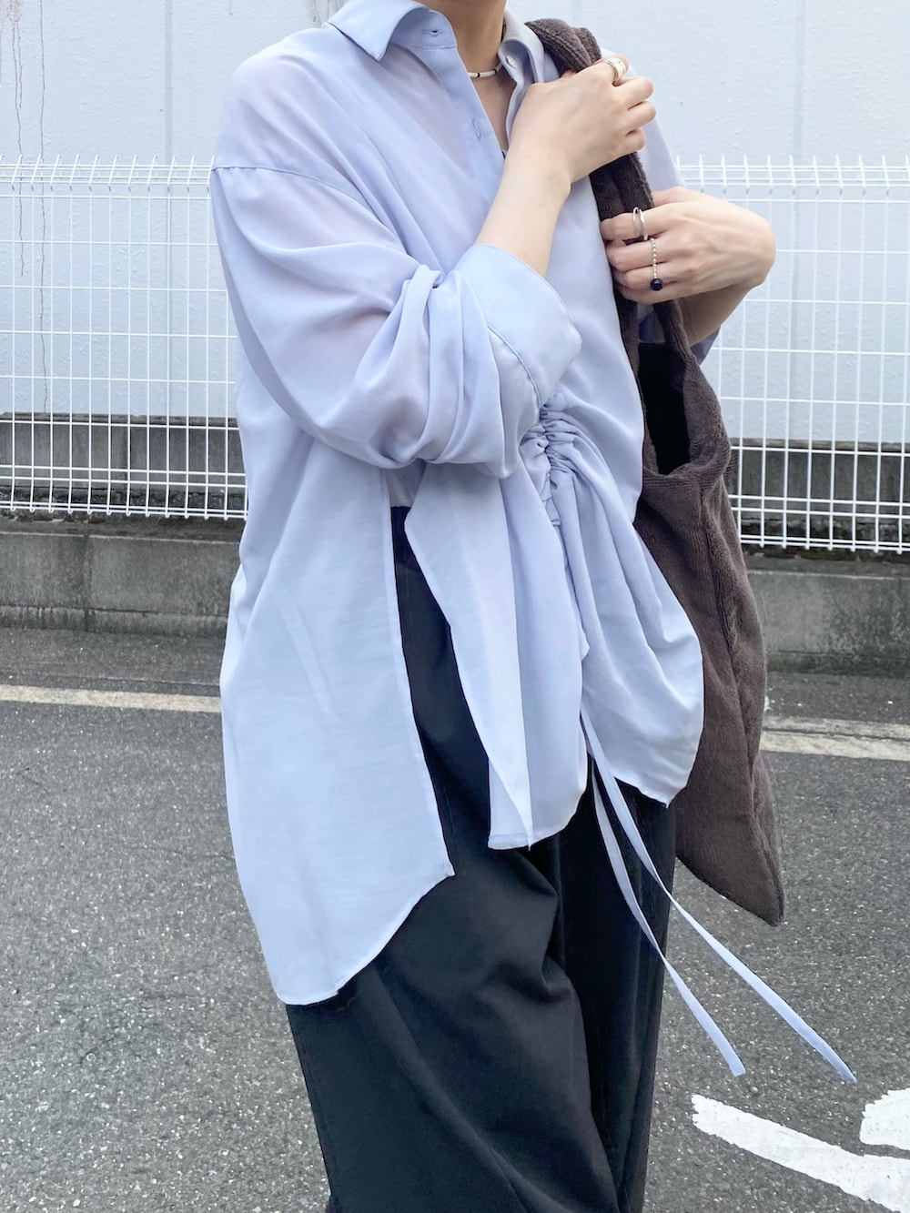 グレー系のその他パンツ、ブルー系のシャツ/ブラウス、ブラウン系のトートバッグを着用したレディースの夏コーディネートの3枚目の写真