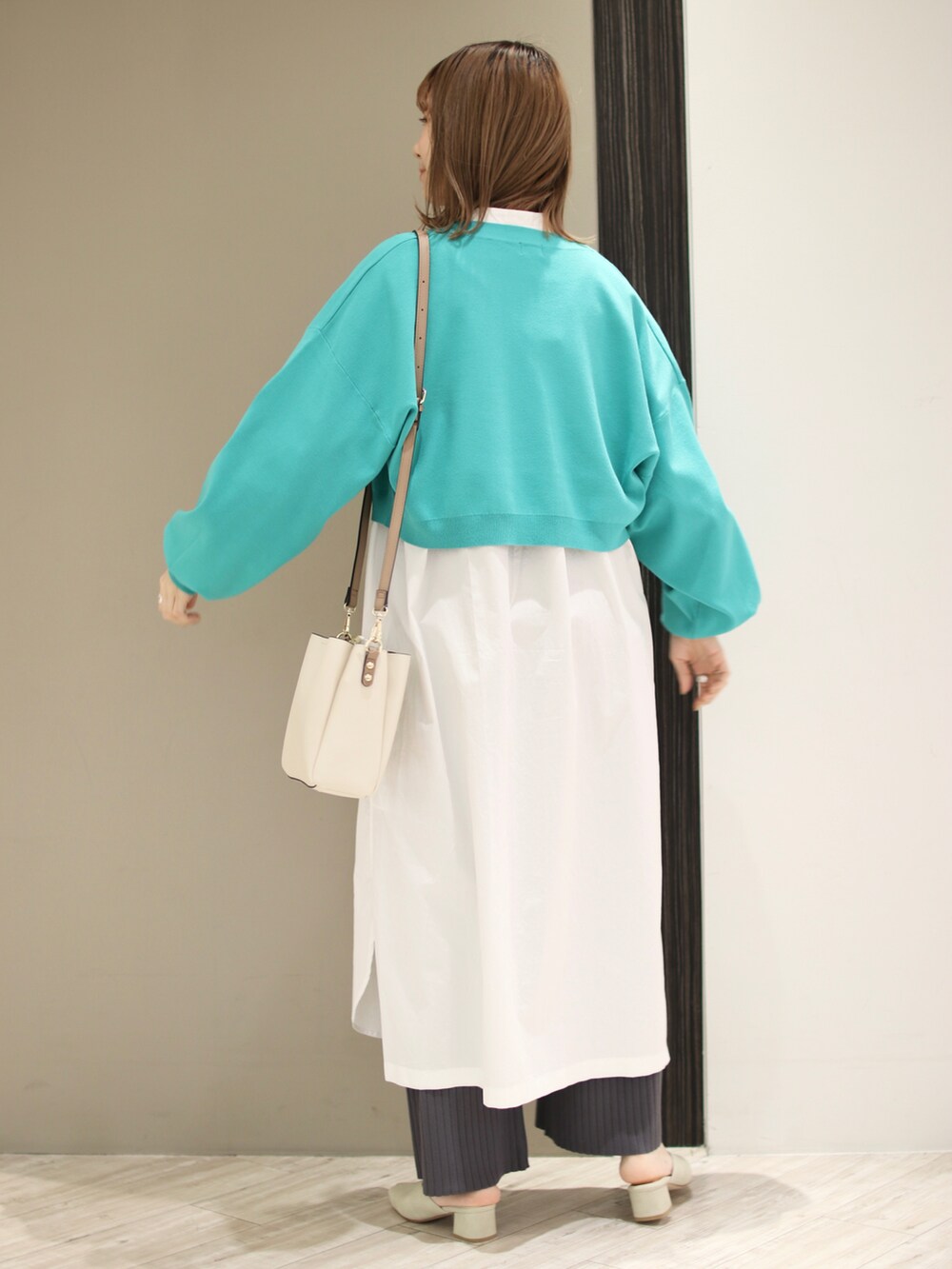 グリーン系のカーディガン/ボレロ、ホワイト系のワンピース、グレー系のその他パンツを着用したレディースの冬コーディネートの3枚目の写真