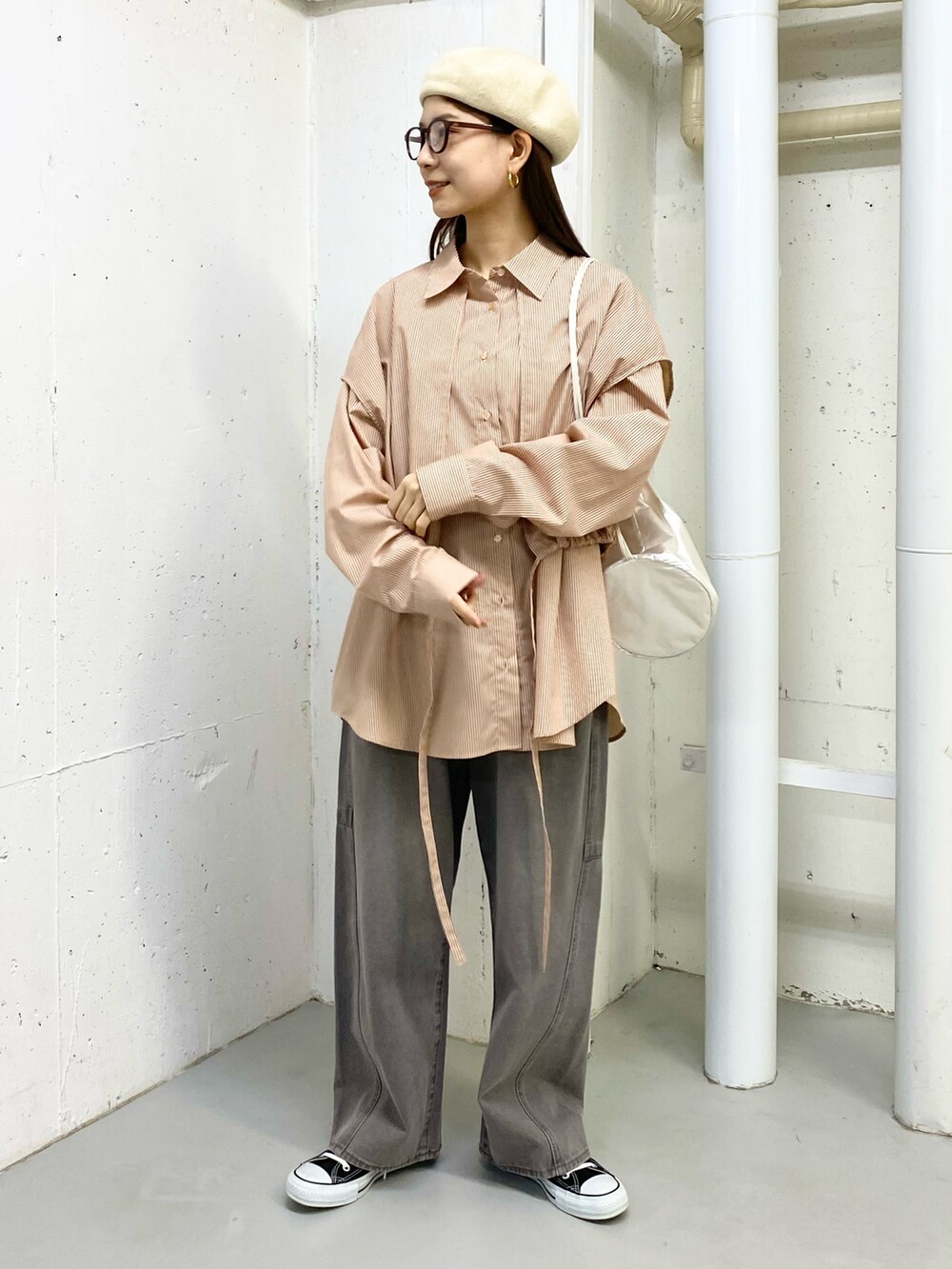 グレー系のデニムパンツ、ベージュ系のシャツ/ブラウス、シルバー系のショルダーバッグを着用したレディースの冬コーディネートの3枚目の写真