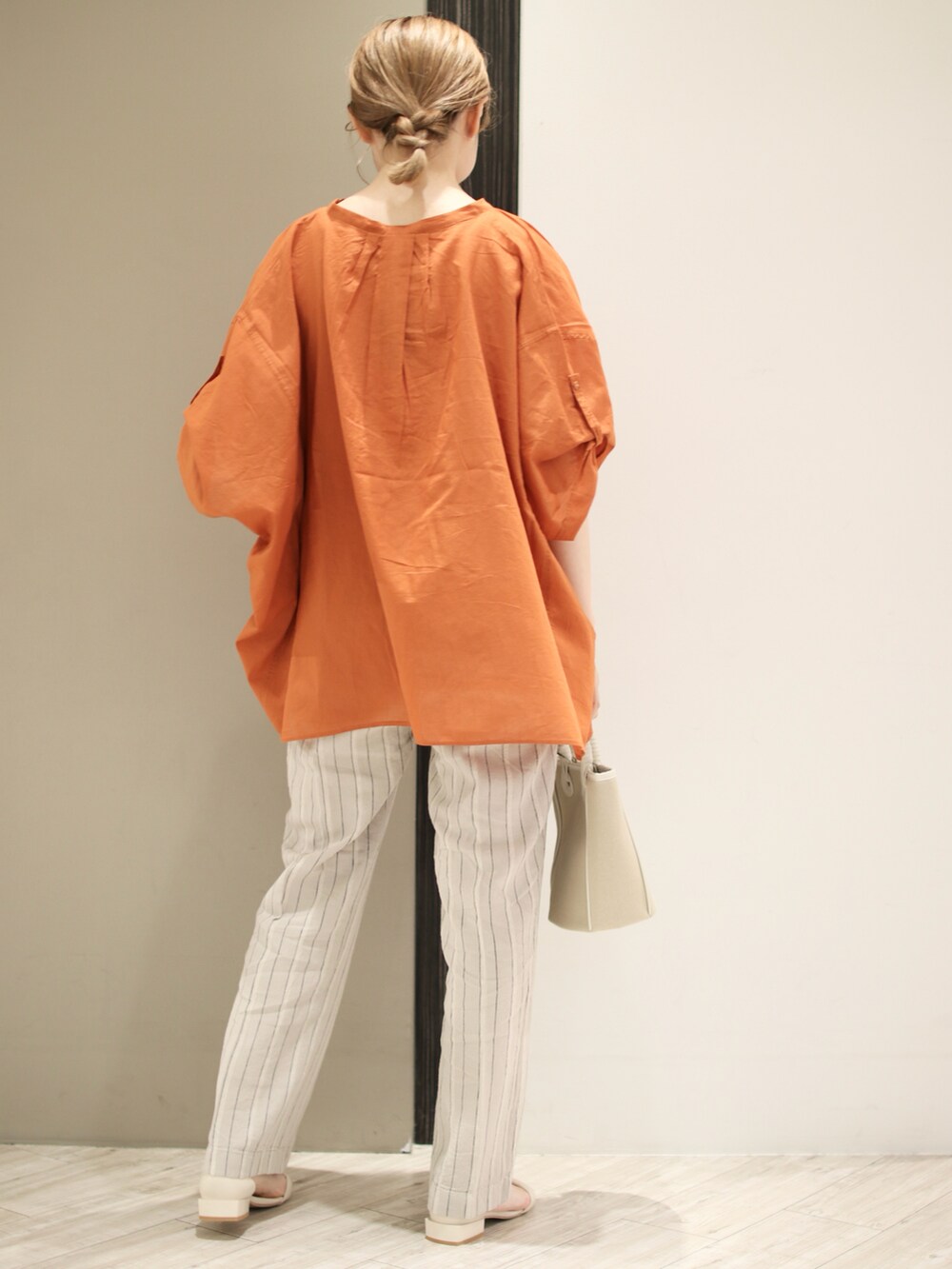 オレンジ系のシャツ/ブラウス、ベージュ系のその他パンツ、ベージュ系のショルダーバッグを着用したレディースの夏コーディネートの4枚目の写真