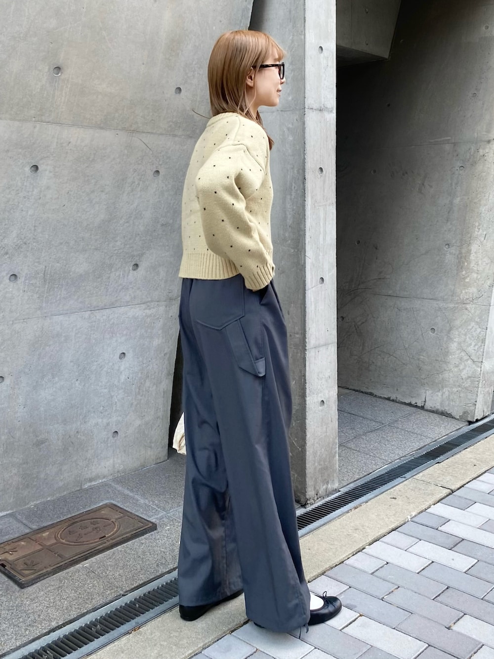 ベージュ系のハンドバッグ、ベージュ系のカーディガン/ボレロ、グレー系のその他パンツを着用したレディースの秋コーディネートの2枚目の写真