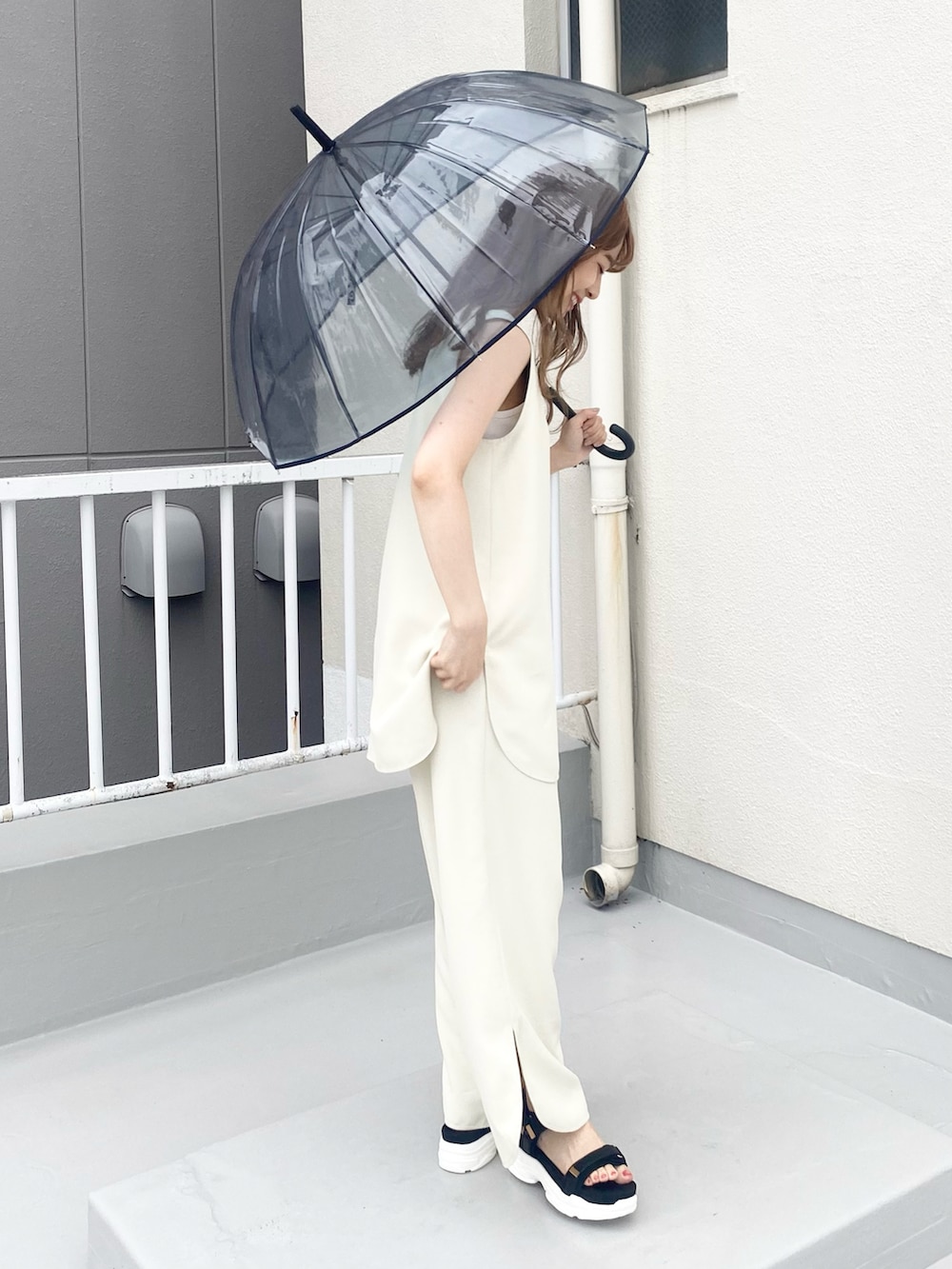 ブラック系のサンダル、ホワイト系のセットアップ、シルバー系のネックレスを着用したレディースの夏コーディネートの3枚目の写真