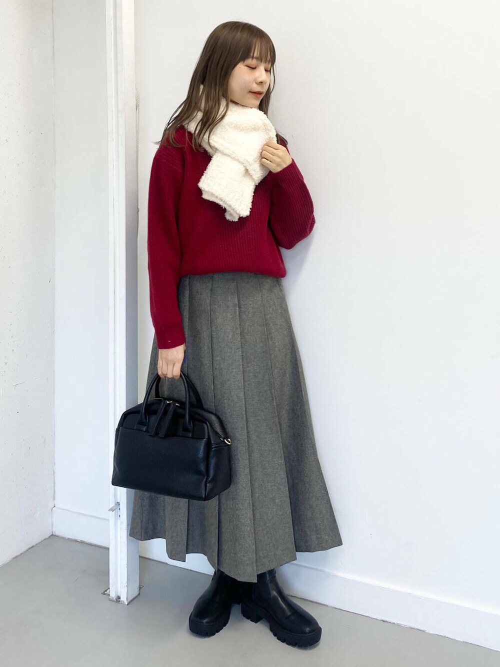 ブラック系のブーツ、ブラック系のボストンバッグ、グレー系のスカートを着用したレディースの冬コーディネートの2枚目の写真