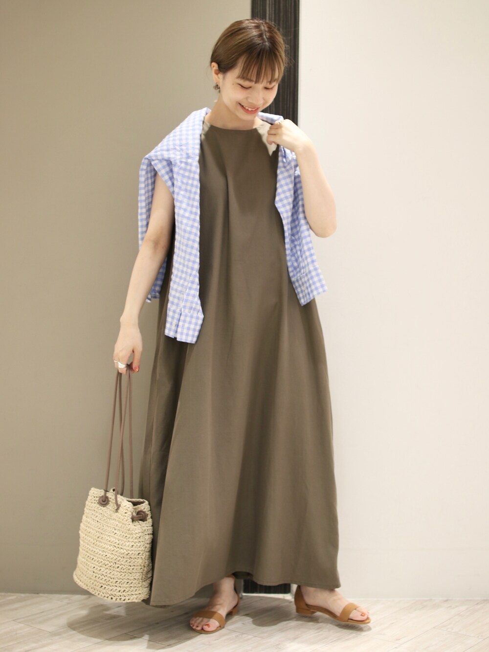 グリーン系のワンピース、ブルー系のシャツ/ブラウス、ベージュ系のショルダーバッグを着用したレディースの夏コーディネートの2枚目の写真