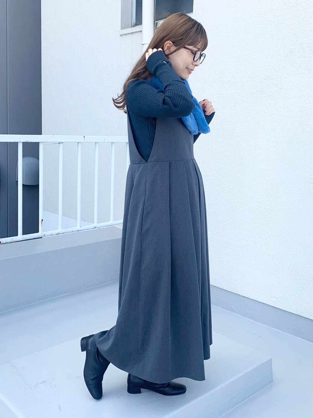 グレー系のワンピース、グリーン系のニット/セーター、ブルー系のマフラーを着用したレディースの秋コーディネートの2枚目の写真