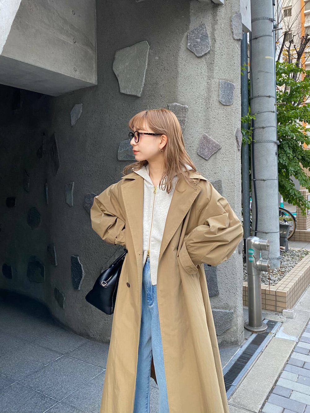 ブラック系のボストンバッグ、ブラック系のブーツ、ベージュ系のパーカーを着用したレディースの冬コーディネートの4枚目の写真