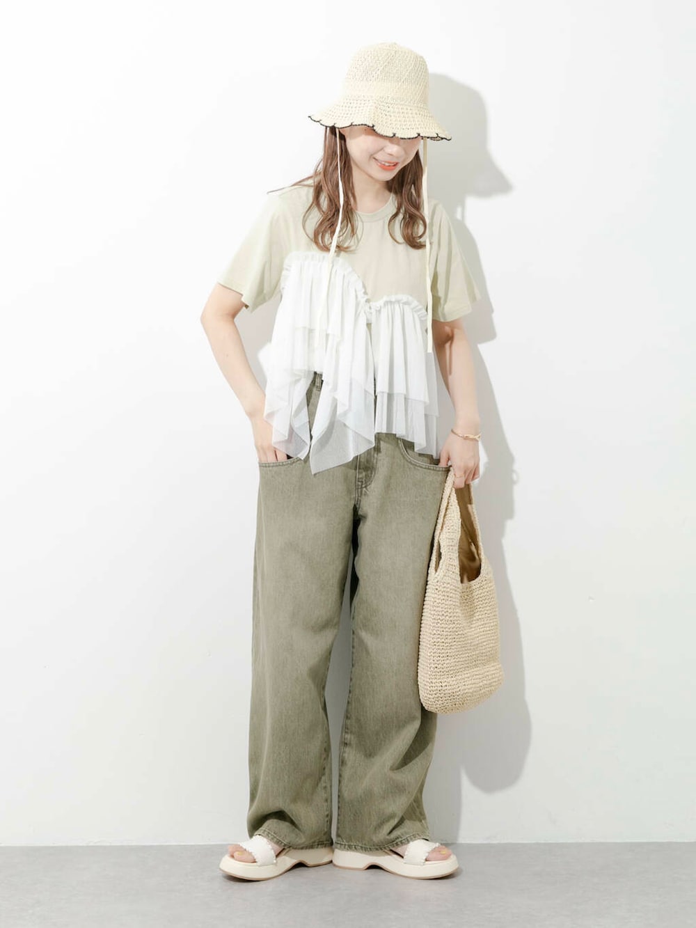 ベージュ系のトートバッグ、グリーン系のTシャツ/カットソー、ホワイト系のサンダルを着用したレディースの夏コーディネートの6枚目の写真