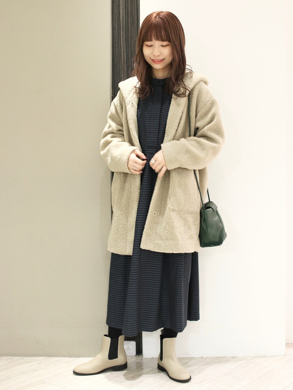 ブルー系のワンピース、ベージュ系のその他アウター、ベージュ系のブーツを着用したレディースの冬コーディネートの5枚目の写真