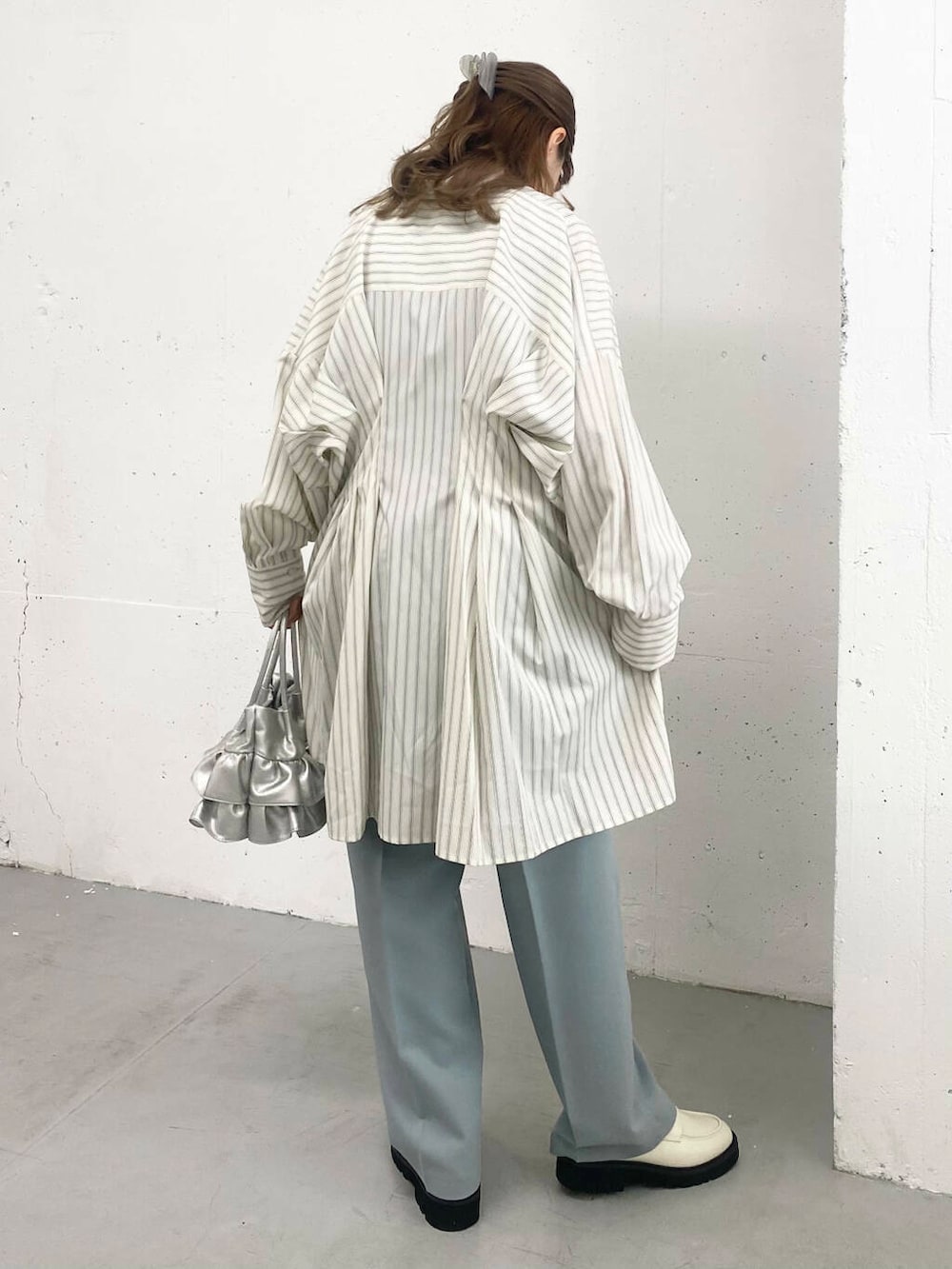 ブルー系のその他パンツ、ホワイト系のローファー、シルバー系のハンドバッグを着用したレディースの春コーディネートの5枚目の写真